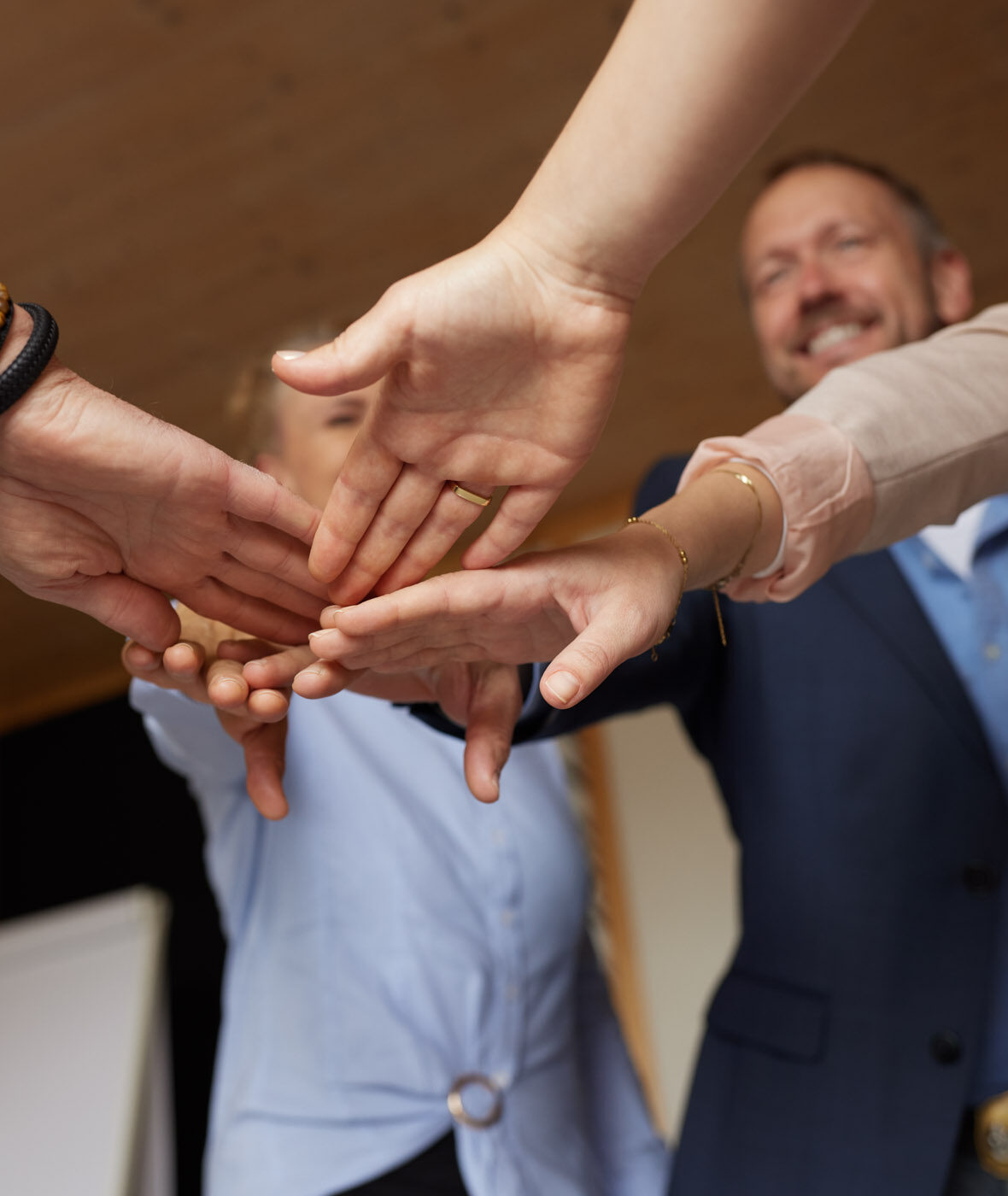 Team‑Geste mit fünf Händen – Symbol für Zusammenhalt & Motivation in der Business Akademie Starnberg