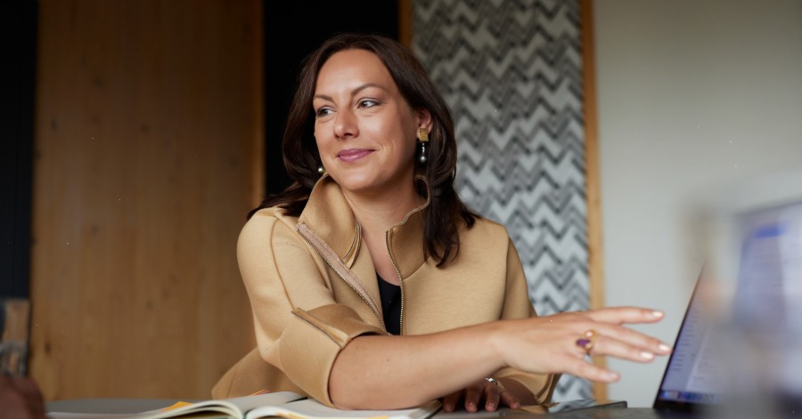 Dr. Franziska Zacher blickt freundlich zu ihrem Gesprächspartner gegenüber. Auf dem Tisch steht ein Laptop.